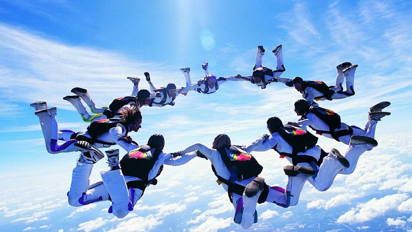 Formazione di paracadutisti VZONE in caduta libera sopra le nuvole
